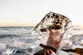 Auf unserer YOUNG LINE Rundreise durch Island im Winter fahren wir zum Diamond Beach, wo unzählige Eisblöcke auf dem schwarzen Sand glitzern.