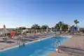 Eine Möglichkeit für einen freien Tag während der Rundreise durch Andalusien: Die Sonnenterrasse des Hotels mit Swimmingpool, Liegestühlen und Palmen, die vorbei an Palmen einen Blick auf das Meer bietet.