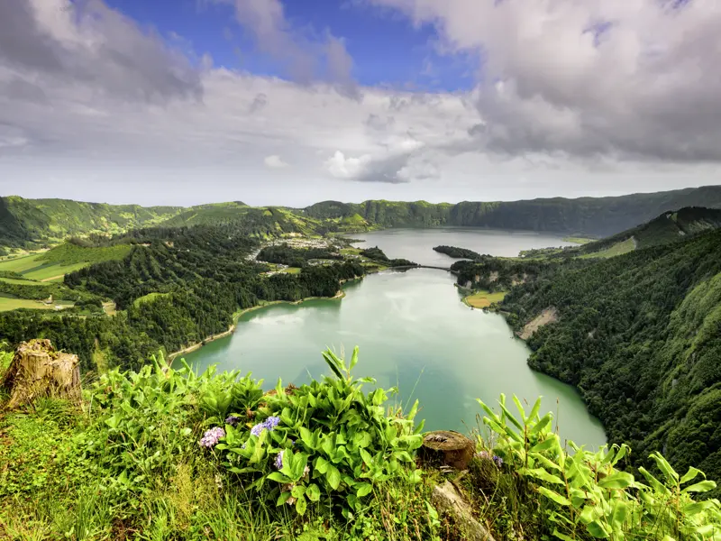 Auf unserer Marco Polo Rundreise auf den Azoren genießen wir auf der Insel Sao Miguel Panoramablicke über die blau und grün leuchtenden Kraterseen von Sete Cidades.