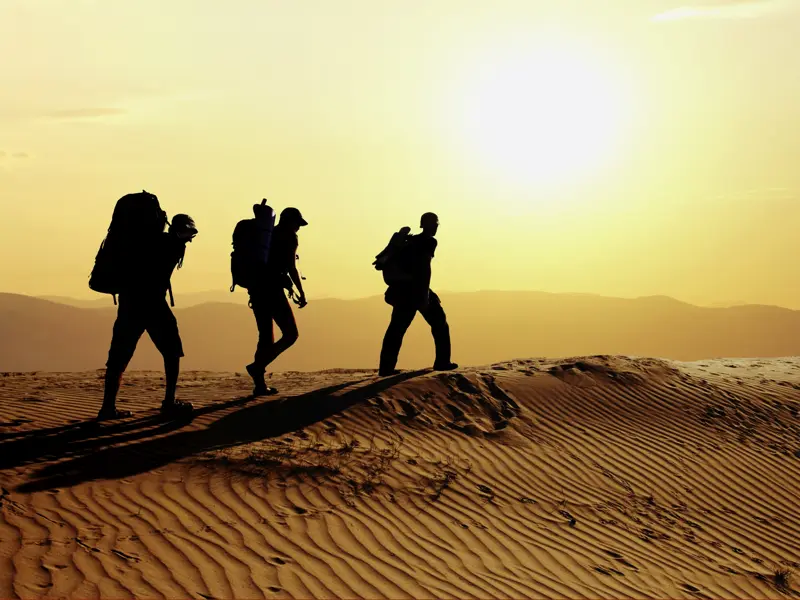 Wanderer in der Wüste Marokkos bei tief stehender Sonne.