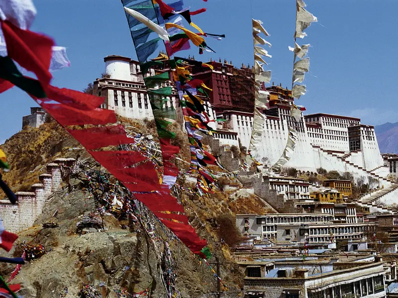 Gebetsfahnen flattern im Wind, der mächtige Potala-Palast thront über der tibetischen Hauptstadt Lhasa, wir schreiten die unzähligen Stufen hinauf und entdecken sein geheimnisvolles Inneres, wo einst der Dalai Lama residierte und seine Gäste empfing.
