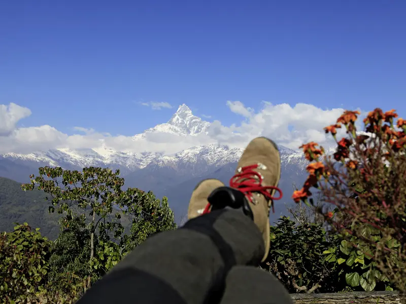 Nach einer Wanderung ist es Zeit, die Füße vor der Kulisse des Himalayas auch mal hochzulegen. Auch Entspannung ist Teil unserer Rundreise durch Nepal.
