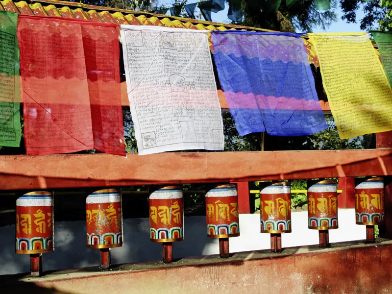 Bald ein vertrauter Anblick auf Ihrer individuellen Rundreise durch Bhutan: bunte Gebetsfahnen und Gebetsmühlen bei den Tempeln.