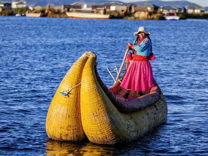 Ihre individuelle Rundreise durch Peru und Bolivien bringt Ihnen auch die Kultur und die Ethnien der beiden Länder nahe. Hier ist eine Uros-Frau auf einem der typischen Boote aus  Binsen auf dem Titicacasee unterwegs.