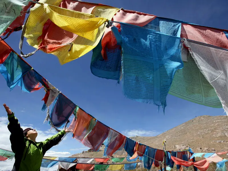 Auf Ihrer individuellen Rundreise durch Tibet bald ein vertrauter Anblick: im Wind flatternde Gebetsfahnen. Im Kloster Sera erfahren Sie von einem Mönch, wie sie bedruckt werden.