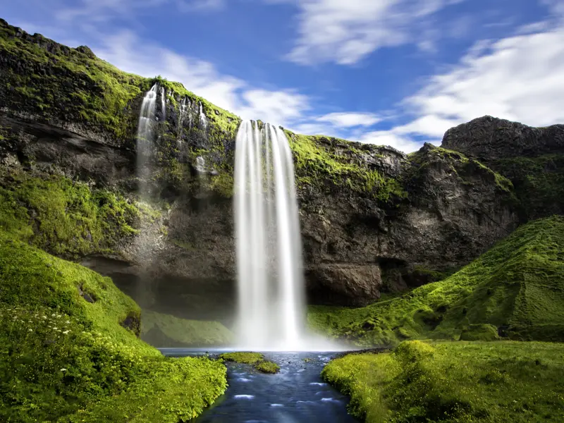 Auf Island gibt es sehr viele imposante Wasserfälle. Der Seljalandsfoss gehört zu den imposantesten. Sie können hinter seiner Wasserschleier spazieren. Aber Vorsicht, Sie werden bestimmt nass!