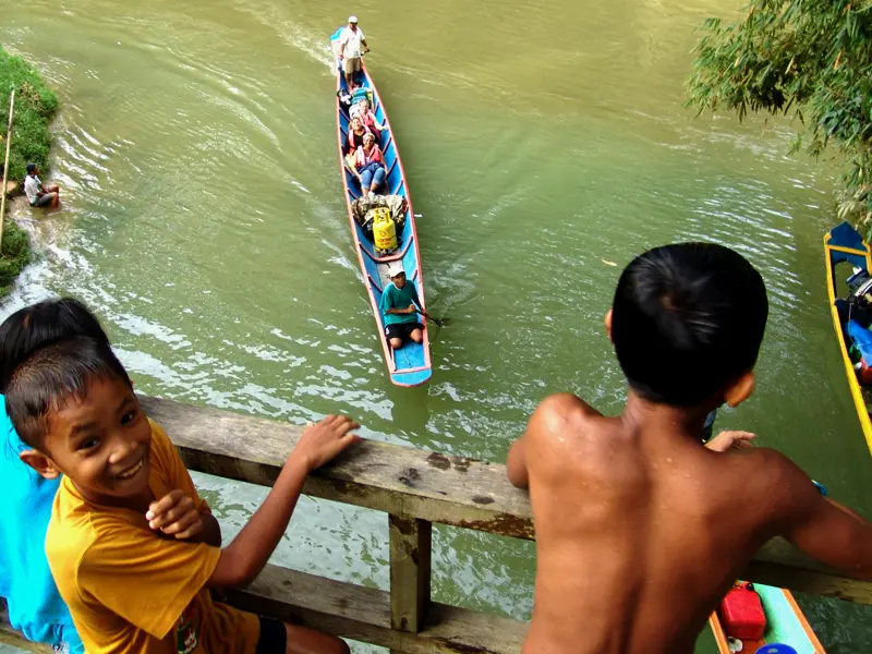 Spaß auf dem Wasser -  Kinder des Volkes Iban in Sarawak beim Baden und Begrüßen von Touristen.