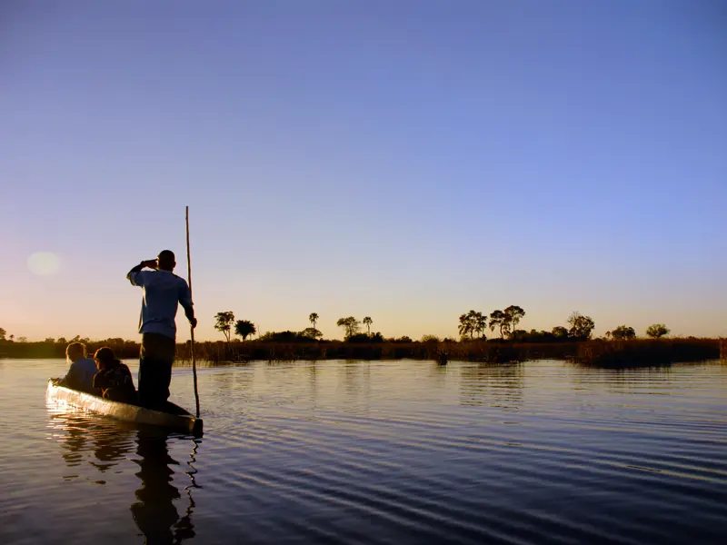 Naturerlebnisse werden bei unserer Rundreise durch Namibia und Botswana großgeschrieben. Die Tour begeistert mit unvergesslichen Eindrücken, hier ein Sonnenuntergang auf einem Boot im Okavangodelta.