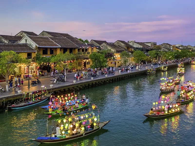 In Hoi An genießen junge Traveller ab 35 gemeinsam die abendliche Stimmung am Fluss.