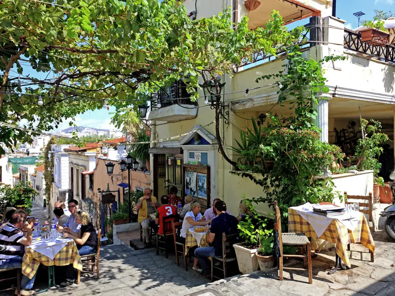 Ein Strassenrestaurant im Altstadtteil Plaka in Athen mit Tischen.