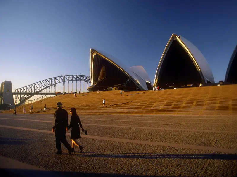 Auf Ihrer individuellen Rundreise durch Australien schauen Sie in Sydney bei einer Führung hinter die Kulissen des Opera House, dessen Architektur an die Segel eines Schiffes erinnert.
