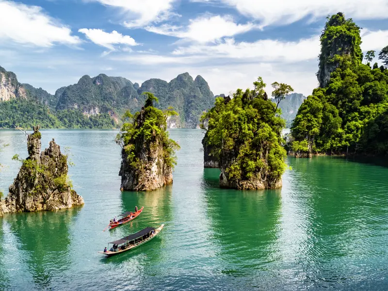 Wir steigen in ein Langschwanzboot und fahren damit über den Chiao-Lan-See im Khao-Sok-Nationalpark. Auf der Bootstour können wir die Kalksteinfelsen, die wie Giganten aus dem Wasser ragen, bestaunen.