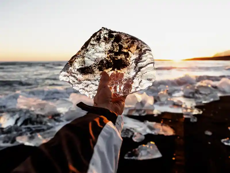 Auf unserer YOUNG LINE Rundreise durch Island im Winter fahren wir zum Diamond Beach, wo unzählige Eisblöcke auf dem schwarzen Sand glitzern.