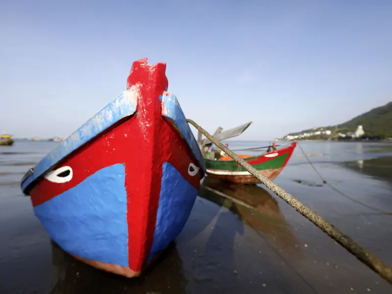 Auf unserer YOUNG LINE Rundreise durch Vietnam und Kambodscha sehen wir auch die bunten Fischerboote am Mekong in einer faszinierenden Kulisse.