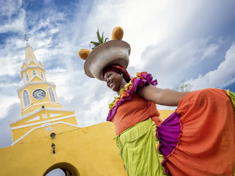 Beim Finale unserer Rundreise durch Kolumbien erkunden wir die prächtig restaurierte Altstadt von Cartagena und begegnen bestimmt auch der ein oder anderen Frau in farbenfroher Tracht.