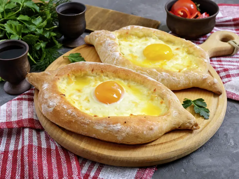 Auf unserer Marco Polo Rundreise durch Georgien backen wir gemeinsam Chatschapuri in einem Kaukasusdorf. Die georgische Pizza ist so lecker, dass man sich gar nicht daran satt essen kann.