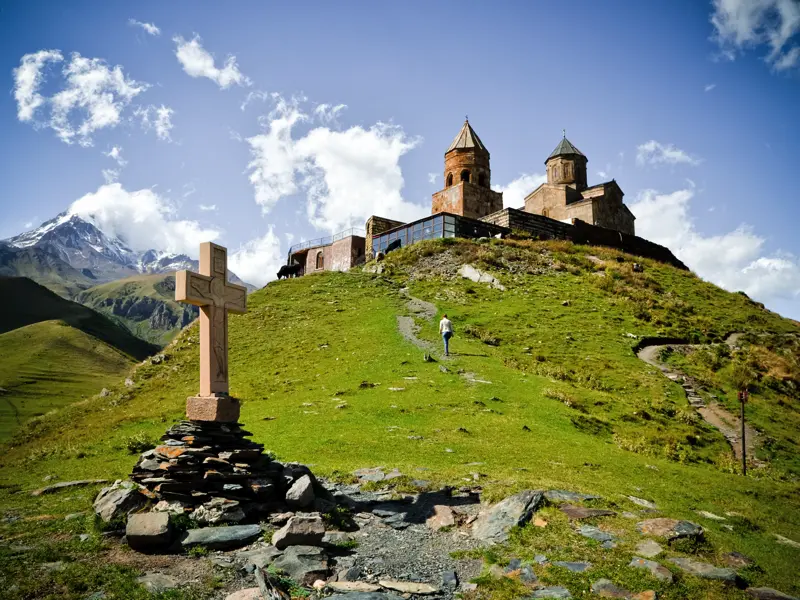 Auf unserer Marco Polo Rundreise erleben wir alle Highlights Georgiens in neun Tagen. Beeindruckend liegt hier die Dreifaltigkeitskirche am Fuße des Kasbek bei Stepantsminda.