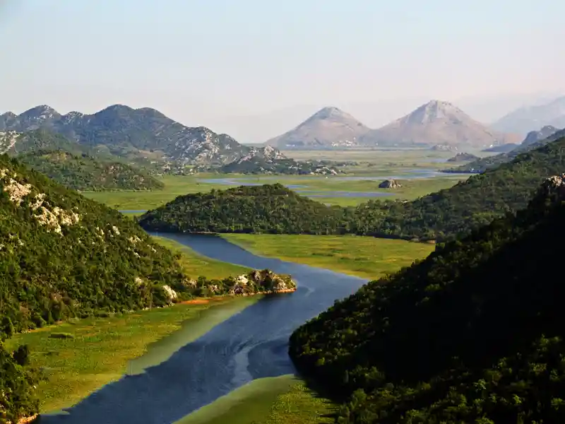 Am 3. Tag der Marco Polo Rundreise in kleiner Gruppe durch Montenegro spazieren wir am Fluss entlang durch die Hügellandschaft zur alten Brücke in Rijeka Crnojevica.