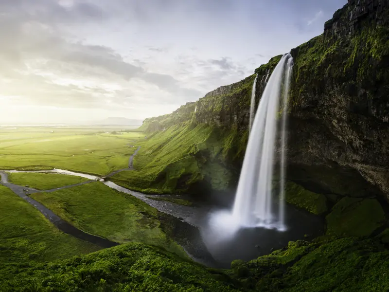 Stoppen Sie beim imposanten Wasserfall Seljalandsfoss, der 40 m tief in sein grünes Becken stürzt. Er lädt Sie dazu ein, einen einmaligen Spaziergang hinter seine Wasserschleier zu wagen.