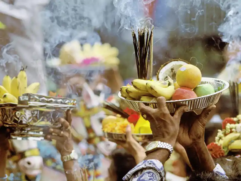 Bestaunen Sie die prächtigen Opfergaben, die vom Duft der Räucherstäbchen umhüllt sind, in einem Tempel in Malaysia.