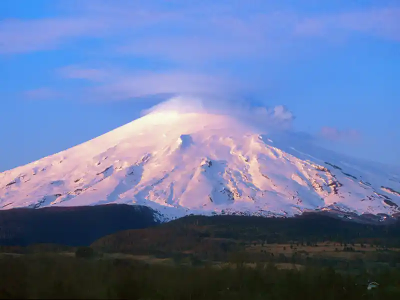 Auf Ihrer individuellen Reise durch Chile geht es hinauf zum Vulkan Osorno (2660 m). Die Straße endet in 1200 m Höhe an einer Berghütte - die Ausblicke von hier auf den sich riesig auftürmenden Vulkan Osorno und die umliegenden Vulkane Calbuco, Antillanca, Tronador und den tiefblauen Llanquihue-See sind unvergesslich. Auf den immensen Lavafeldern des Vulkans unternehmen Sie eine Wanderung.