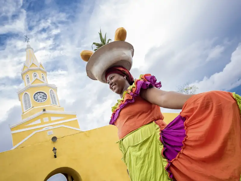 Beim Finale unserer Rundreise durch Kolumbien erkunden wir die prächtig restaurierte Altstadt von Cartagena und begegnen bestimmt auch der ein oder anderen Frau in farbenfroher Tracht.